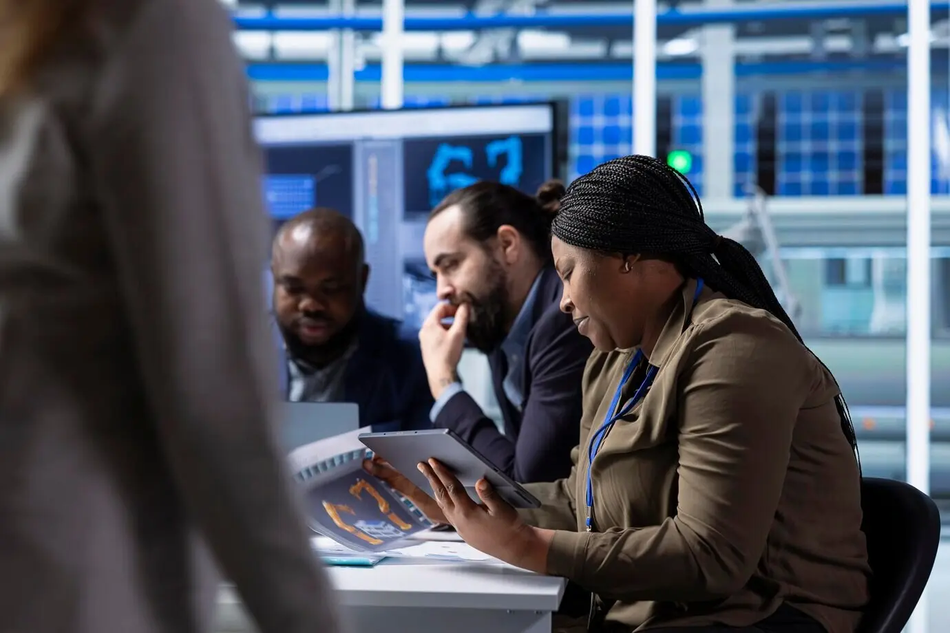 Ejecutivos de la gerencia de una fábrica fotovoltaica revisan esquemas en una tableta.