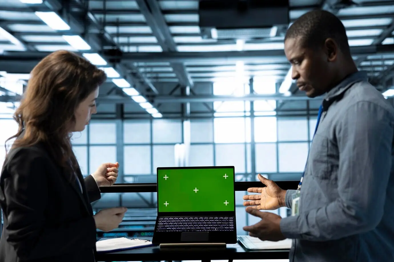 Ingenieros en un centro de datos utilizando un portátil con maqueta de pantalla aislada.