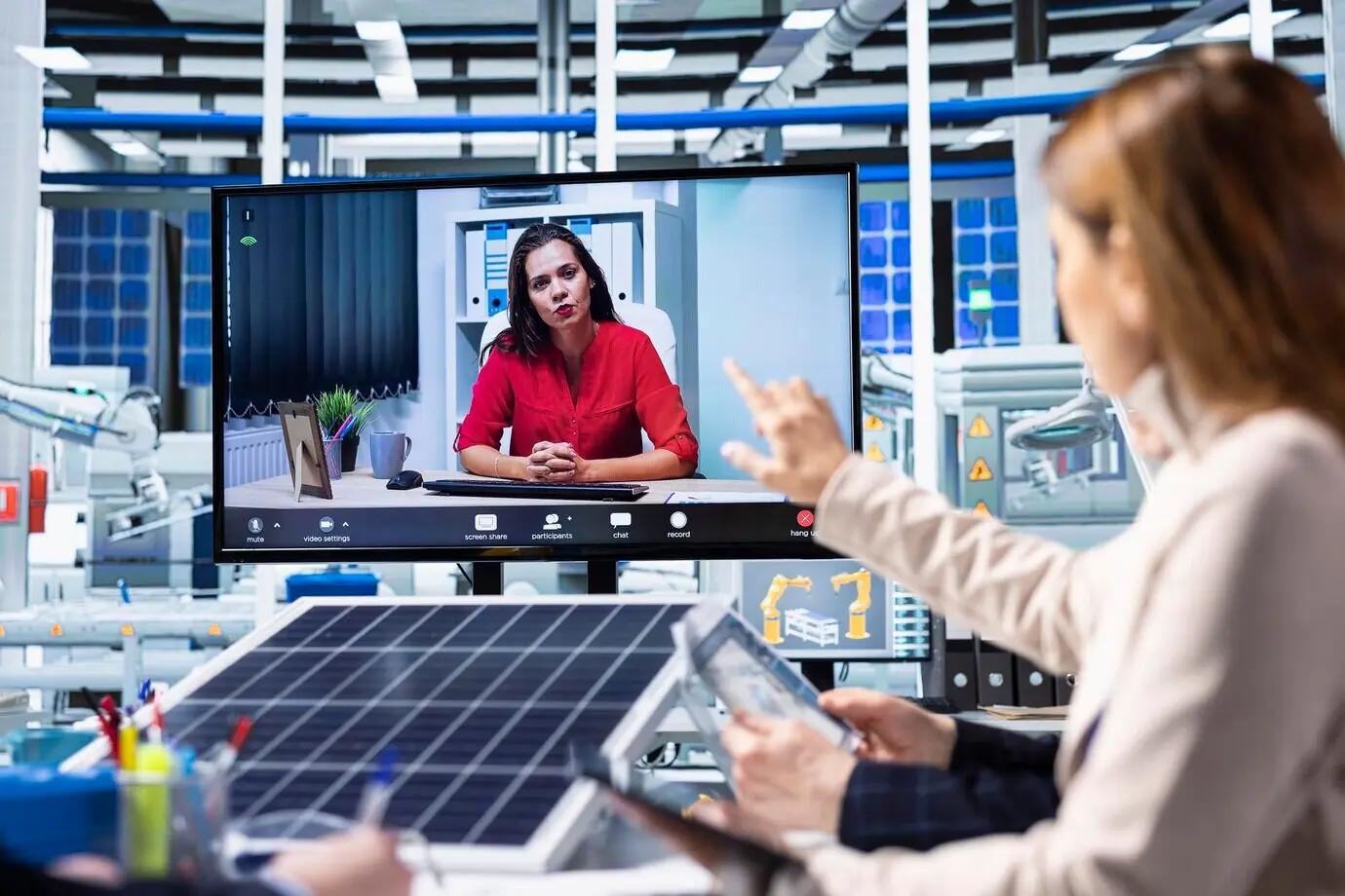Inversores que invierten en una fábrica analizan los flujos de ingresos durante una videoconferencia.